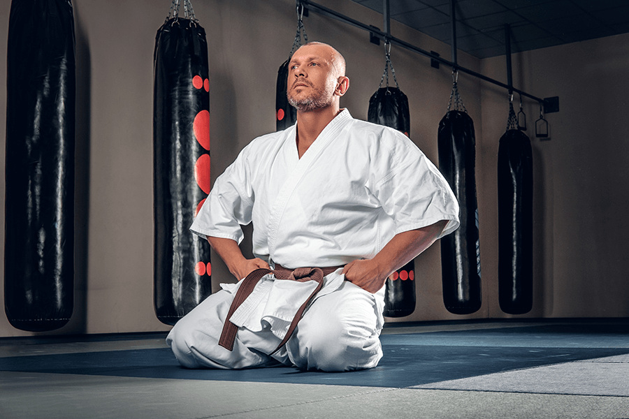 Shaved Head Karate Fighter Sits Tatami Gym, Guido&#039;s Martial Arts Academy